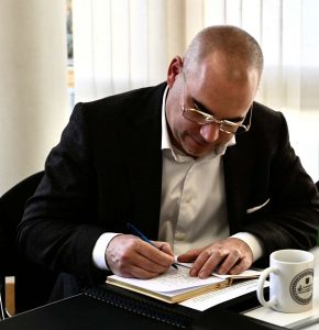 Bürgermeister Christian Eheim schreibt während der Vorstellung von Aussicht im Wandel in ein Gästebuch..