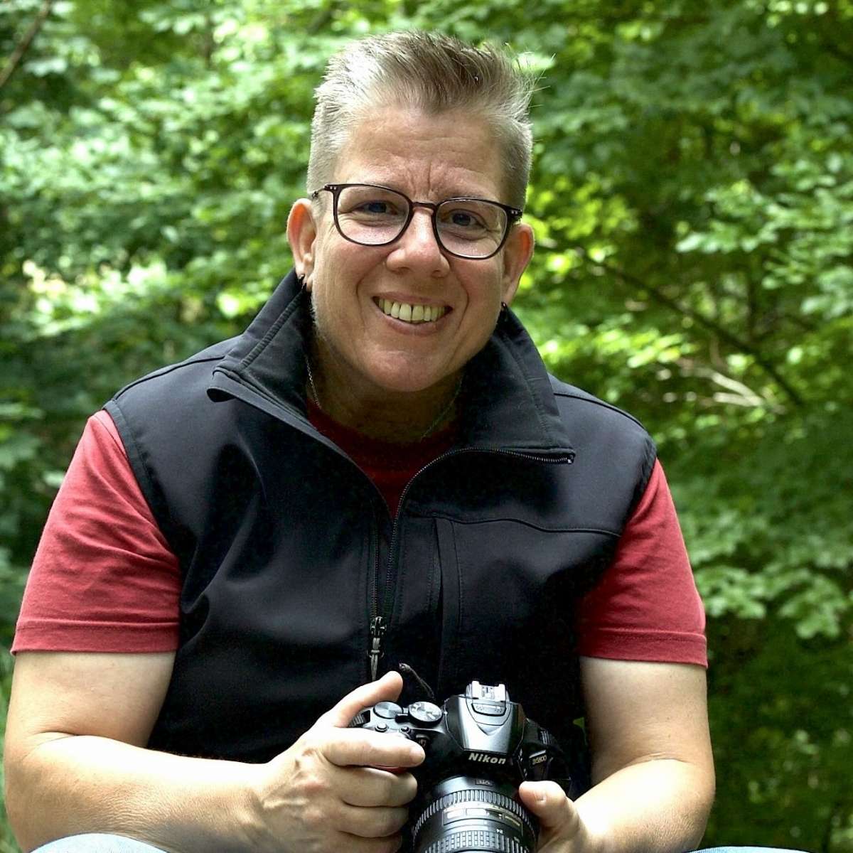 Moosbewachsener Baumstamm mit herzförmiger Maserung im Wald.